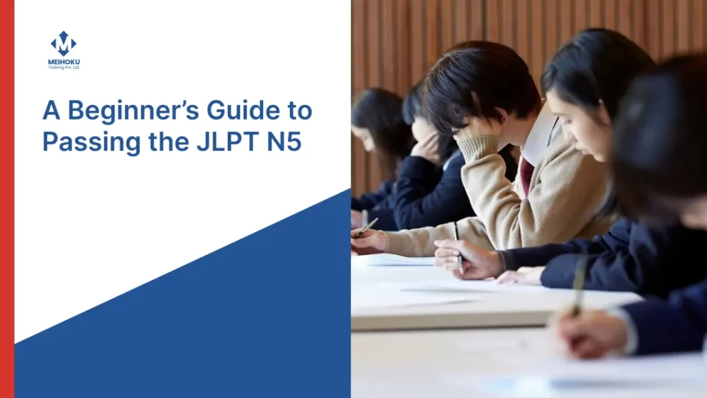 An educational graphic titled 'A Beginner's Guide to Passing the JLPT N5'. The left side features a clean white background with the Meihoku Training Pvt. Ltd. logo and the title in bold blue text. The right side is a photograph showing students in a classroom setting, deeply focused on writing their exam papers. A large, dark blue diagonal block anchors the bottom left of the design.